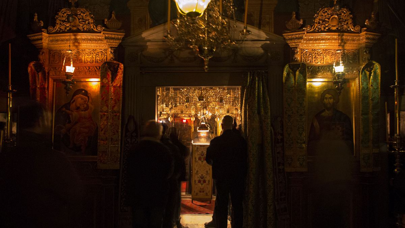 The shrines in the entrance hall; in the central nave, Mass is being conducted.