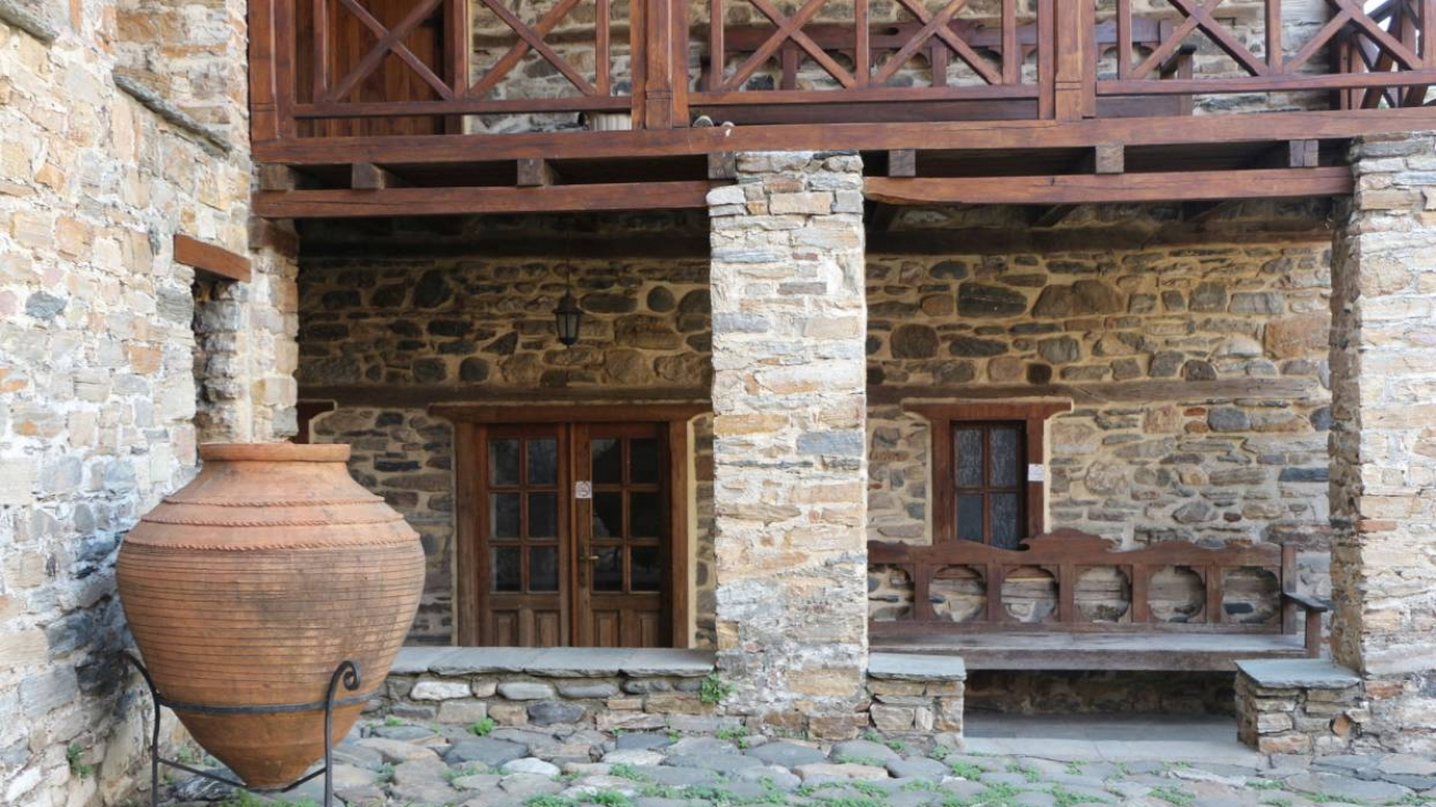 Detail from the courtyard, where a clay storage vessel (pithari) is visible.