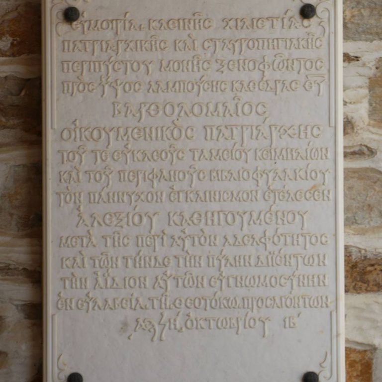 Η αναμνηστική επιγραφή των εγκαινίων του νέου Σκευοφυλακίου, από τον Οικουμενικό Πατριάρχη Βαρθολομαίο, κατά τους εορτασμούς της χιλιετηρίδας της Μονής.
